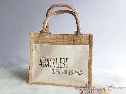 Abgebildet ist die kleine Jutetasche: #Backliebe - rezepte von Herzen + Kochmützensymbol. personalisiere dir eine ganz persönliche Jutetasche mit deinem Lieblingsspruch, Lieblingswort und Symbol. Auch eine geeignete Tasche für den JGA