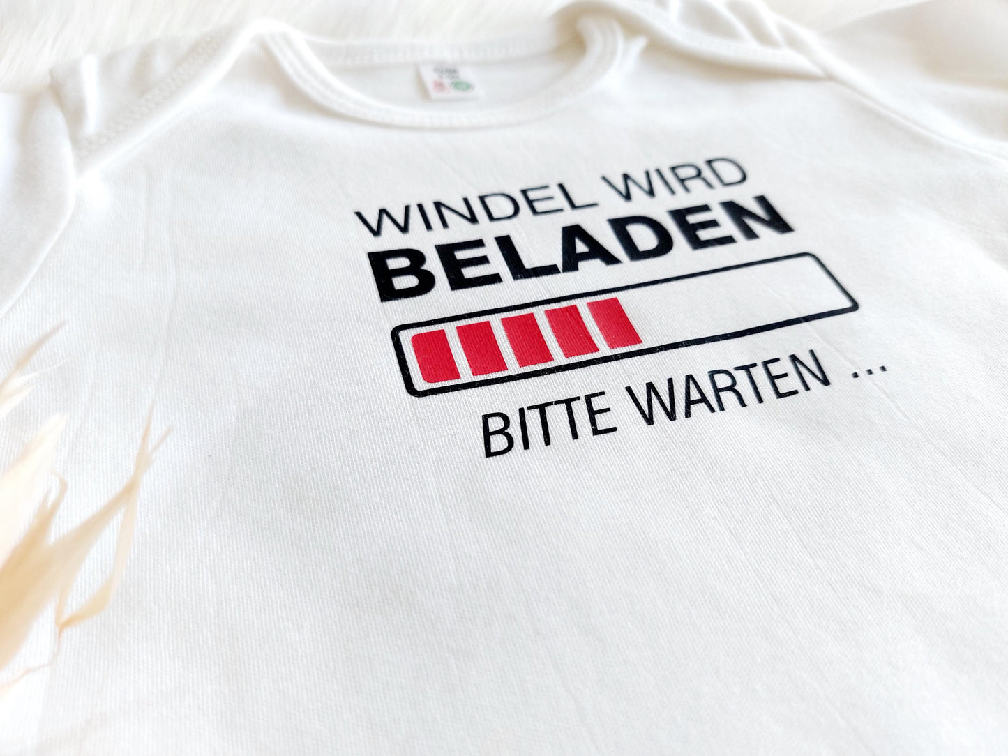 Nahaufnahme von Aufdruck des Baby Body. Windel wird beladen - bitte warten... Tolles Geschenk zur Geburt, zum 1. Geburtstag, zur Taufe oder zur Babyparty. Bedruckter weißer baby Body langarm. Hergestellt bei SelfmadeStduio