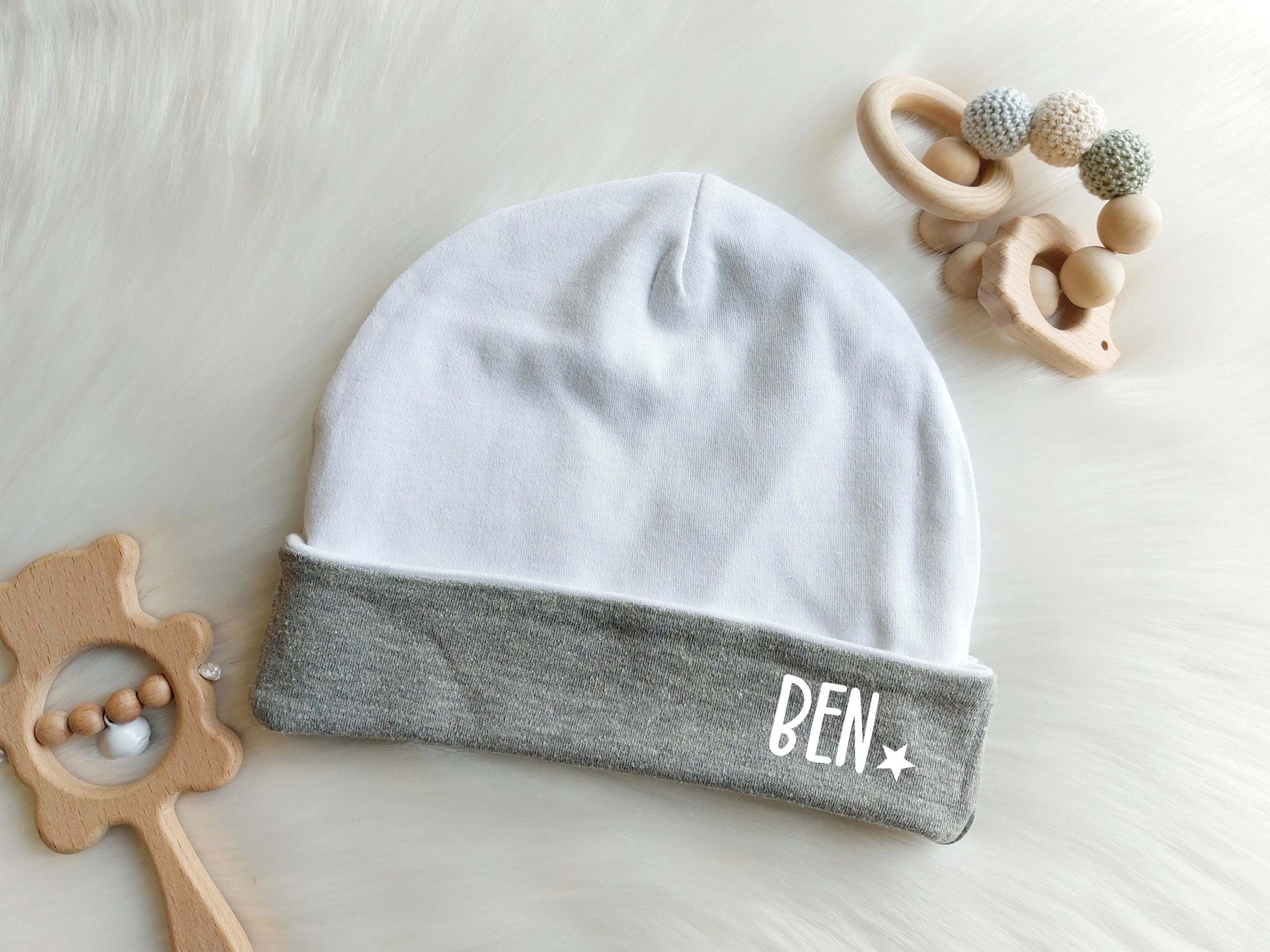 Baby Mütze weiß mit grauem Einschlag. Schriftzug (Schrift 2) &quot;Ben&quot; in Weiß mit Stern Symbol. Ideale Baby Kleidung zum Verschenken an werdende Eltern. Tolles Geschenk zur Taufe oder zur Geburt, oder bereits zur Babyparty. Schönes Newborn Kleidung Set