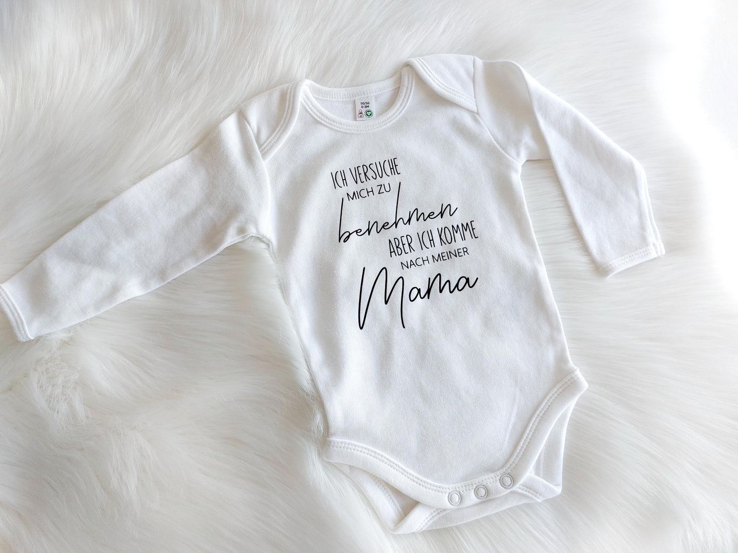 Weißer baby Body mit schwarzem Aufdruck. Spruch: Ich versuche mich zu benehmen, aber ich komme nach meiner Mama. Auch als Papa Version erhältlich. Der Baby Body ist auch 100 % Baumwolle und bei 60 Grad waschbar. Tolles Geschenk für werdende Eltern.